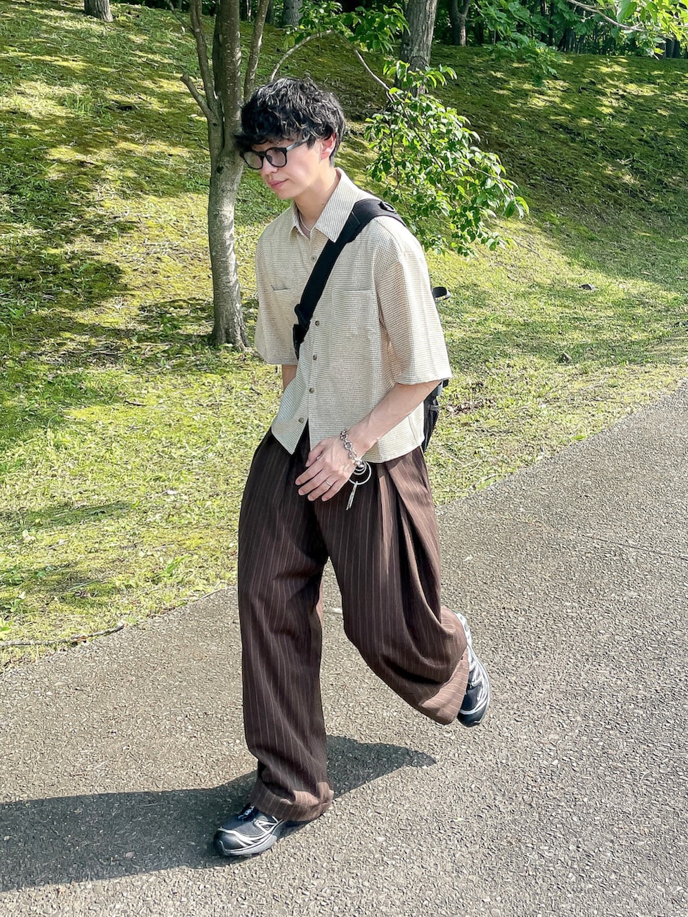 ベージュ系のシャツ/ブラウス、ブラウン系のスラックス、ブラック系のスニーカーを着用したメンズの夏コーディネートの3枚目の写真