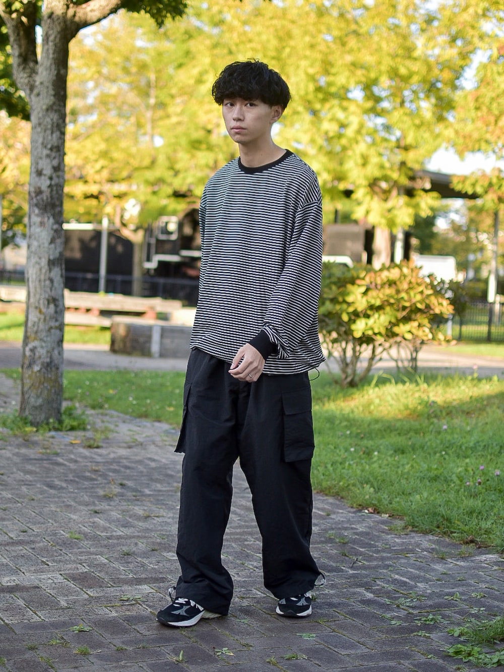 ブラック系のシューズ、ブラック系のカーゴパンツ、ブラック系のTシャツ/カットソーを着用したメンズの秋コーディネートの5枚目の写真