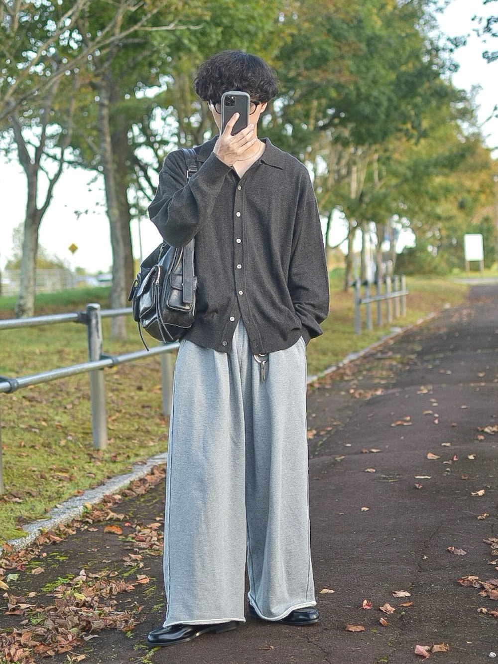 ブラウン系のカーディガン/ボレロ、グレー系のスウェットパンツ、ブラック系のローファーを着用したメンズの秋コーディネートの4枚目の写真