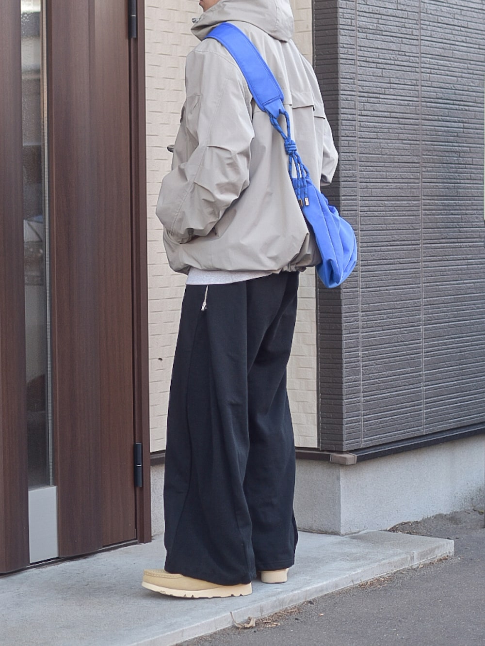 ブラック系のスウェットパンツ、ベージュ系のマウンテンパーカー、グレー系のスウェットを着用したメンズの秋コーディネートの3枚目の写真