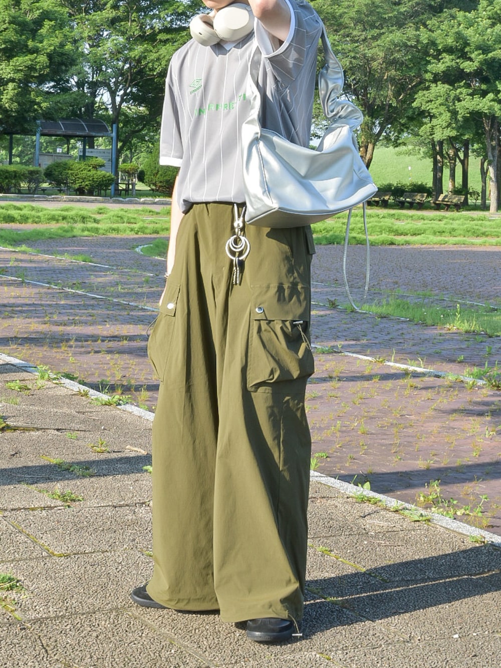 グレー系のTシャツ/カットソー、グリーン系のカーゴパンツ、ブラック系のスニーカーを着用したメンズの夏コーディネートの4枚目の写真