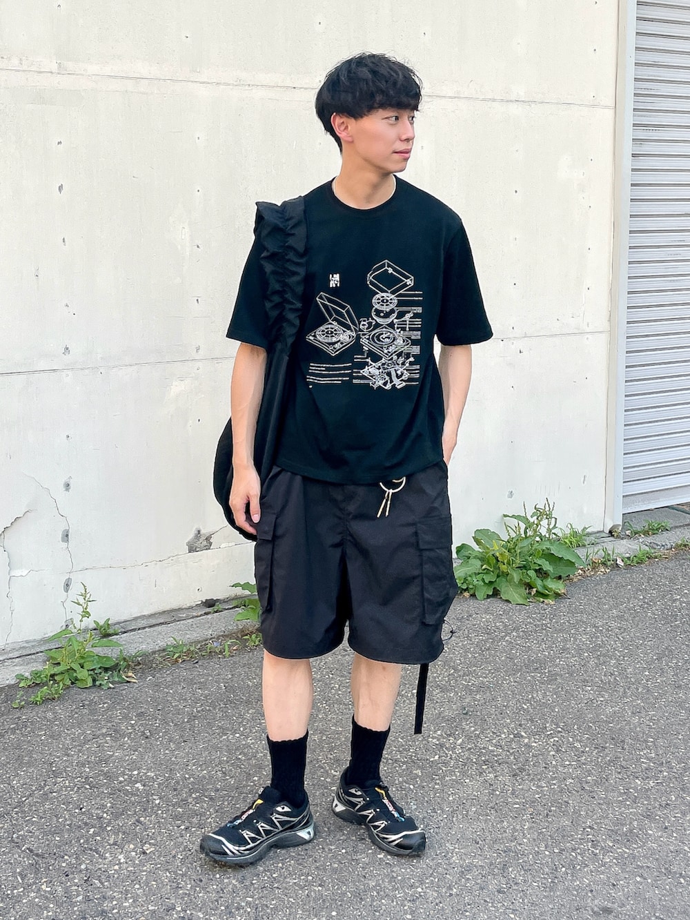 ブラック系のTシャツ/カットソー、ブラック系のスニーカー、ブラック系のショルダーバッグを着用したメンズの夏コーディネートの3枚目の写真