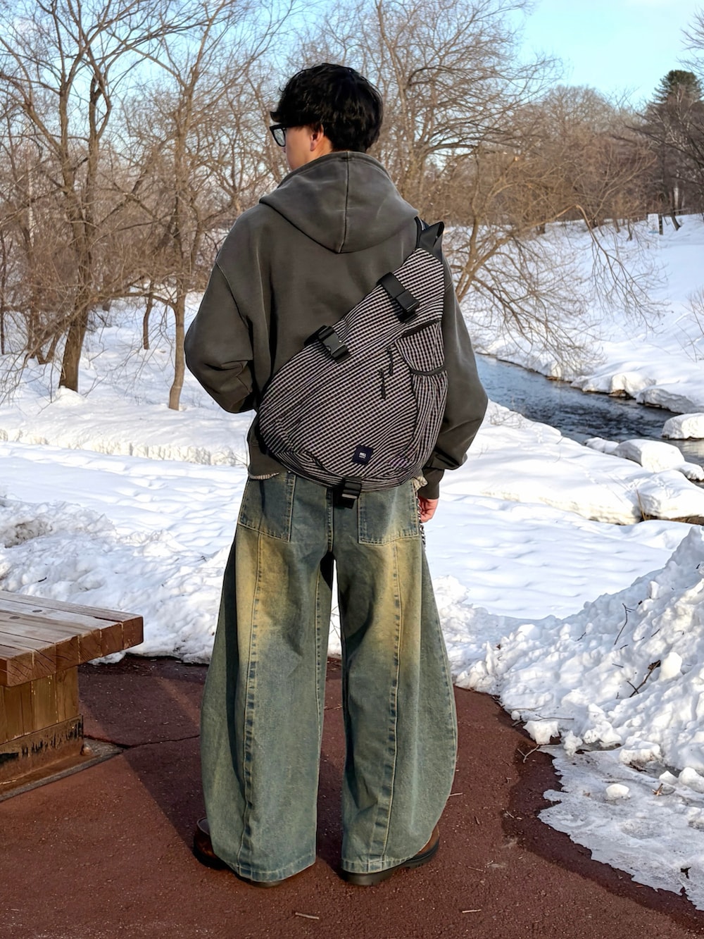 ブルー系のデニムパンツ、グレー系のパーカー、ブラック系のボディバッグ/ウエストポーチを着用したメンズの冬コーディネートの4枚目の写真