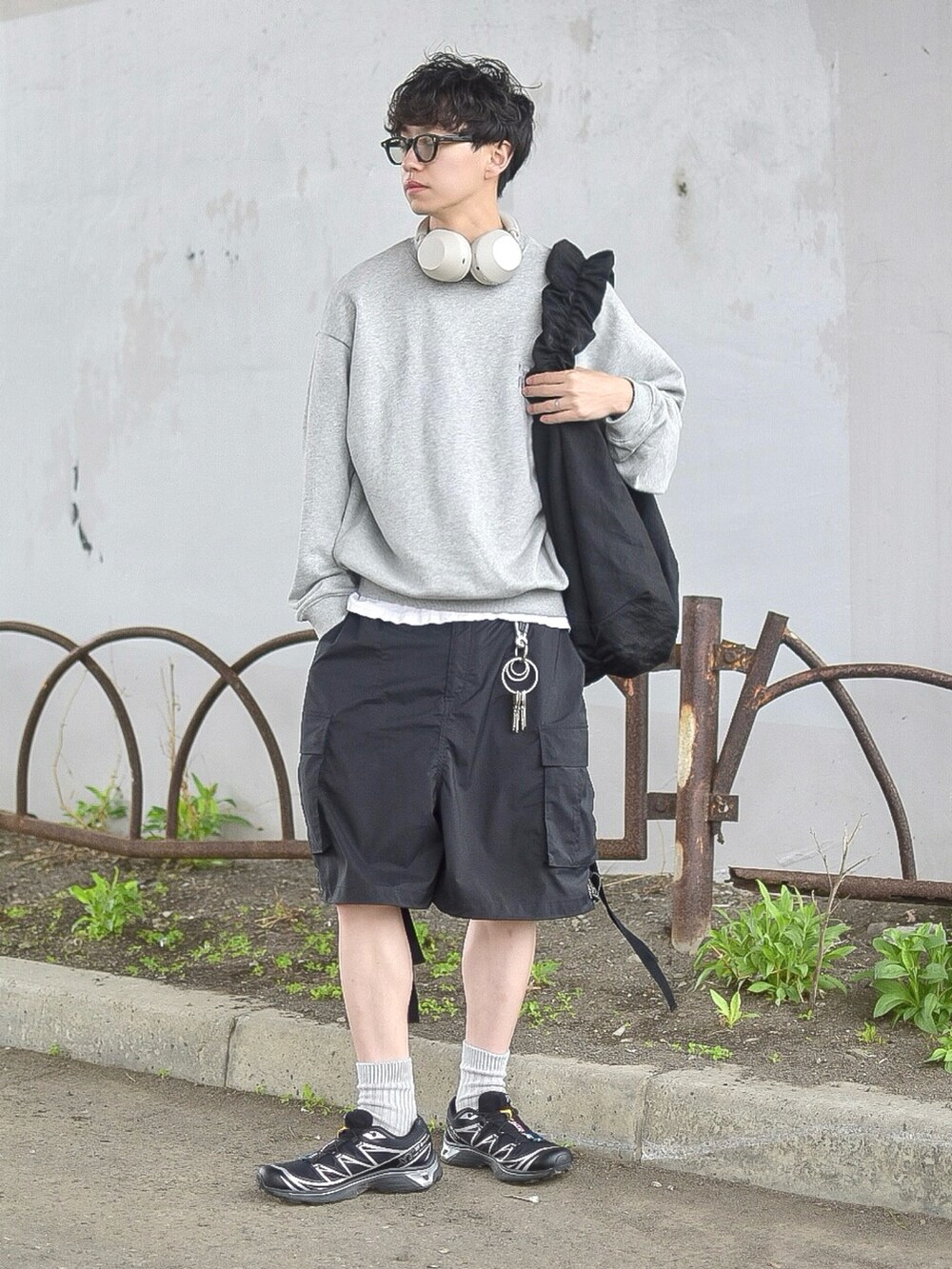 グレー系のスウェット、ブラック系のカーゴパンツ、ブラック系のスニーカーを着用したメンズの春コーディネートの2枚目の写真