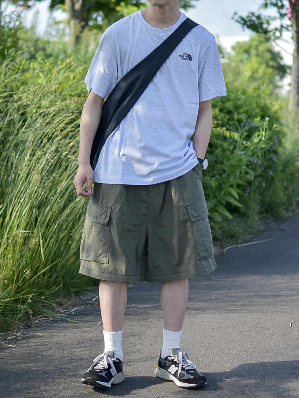 ホワイト系のTシャツ/カットソー、グリーン系のカーゴパンツ、ブラック系のシューズを着用したメンズの夏コーディネートの2枚目の写真