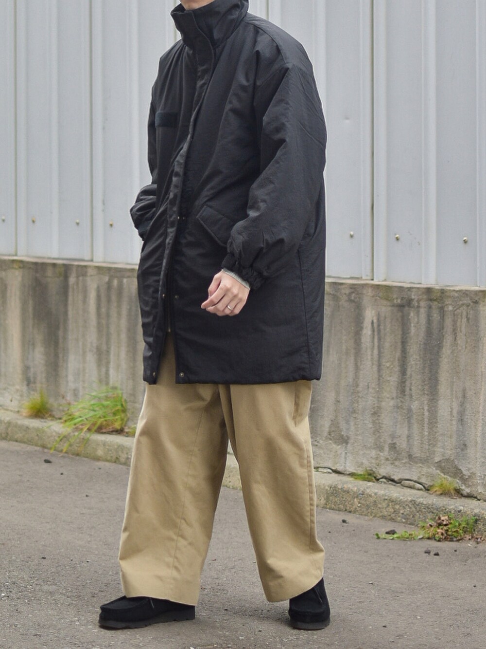 グレー系のニット/セーター、ベージュ系のその他パンツ、ブラック系のキャップを着用したメンズの秋コーディネートの5枚目の写真
