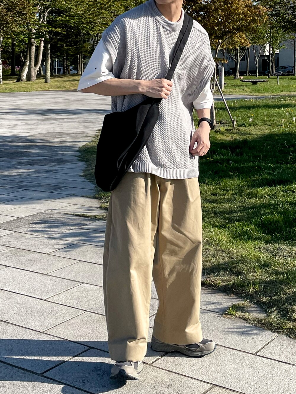 グレー系のベスト、ベージュ系のその他パンツ、グレー系のスニーカーを着用したメンズの夏コーディネートの2枚目の写真