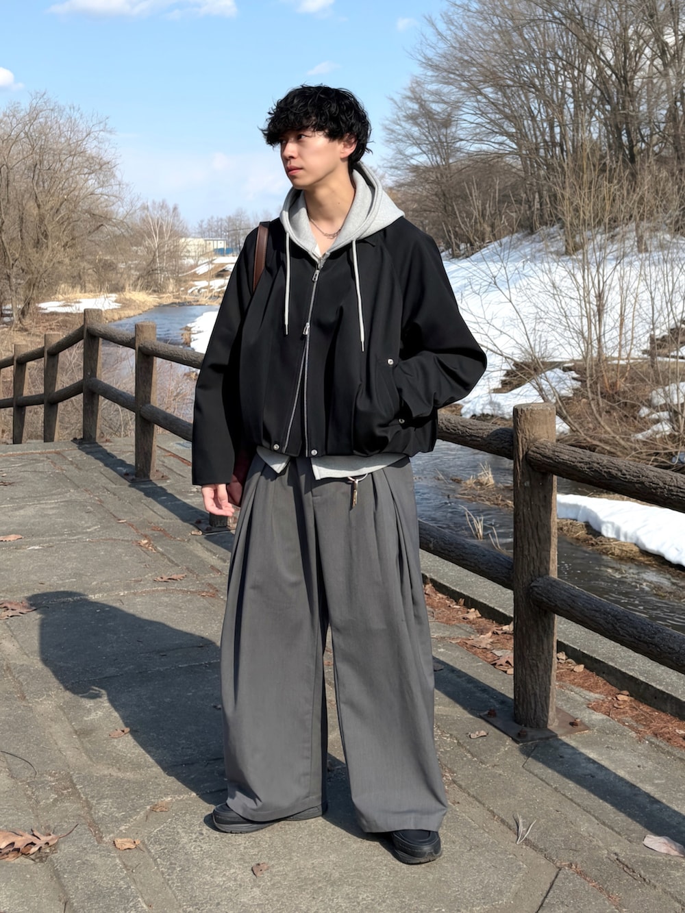 その他のブルゾン、ブラウン系のショルダーバッグ、グレー系のスラックスを着用したメンズの春コーディネートの3枚目の写真