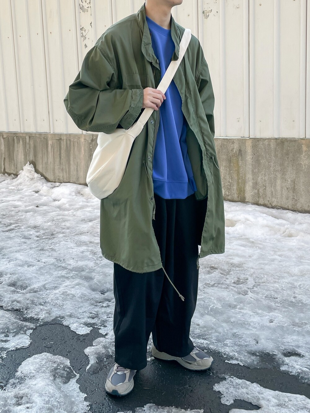 ブルー系のスウェット、ブラック系のチノパンツを着用したメンズの春コーディネートの2枚目の写真