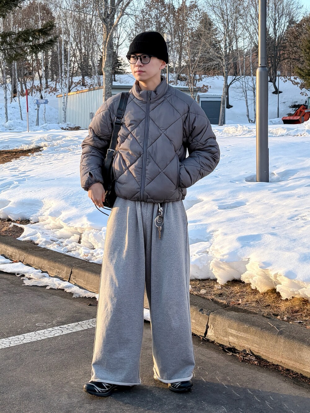 グレー系のダウンジャケット/コート、グレー系のニット/セーター、グレー系のスウェットパンツを着用したメンズの冬コーディネートの2枚目の写真