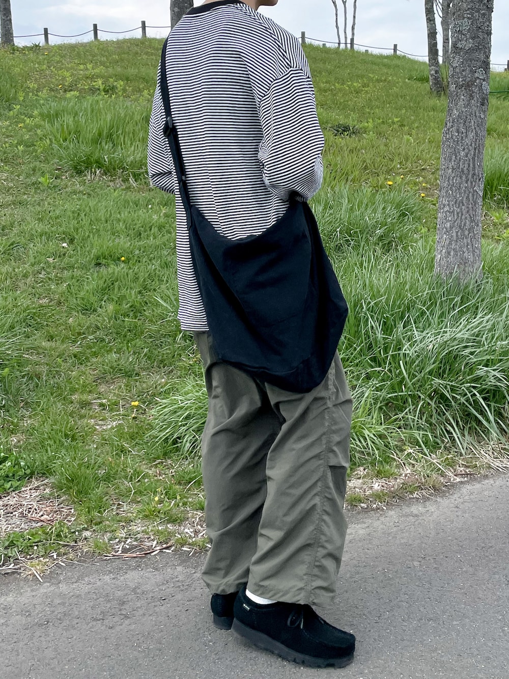 ブラック系のTシャツ/カットソー、グリーン系のパンツを着用したメンズの春コーディネートの3枚目の写真