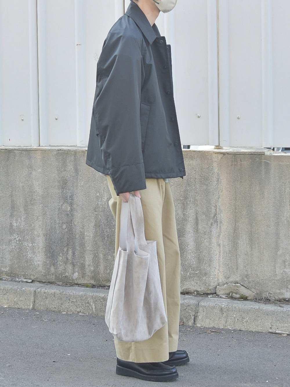 ブラック系のその他アウター、ベージュ系のトートバッグを着用したメンズの春コーディネートの4枚目の写真