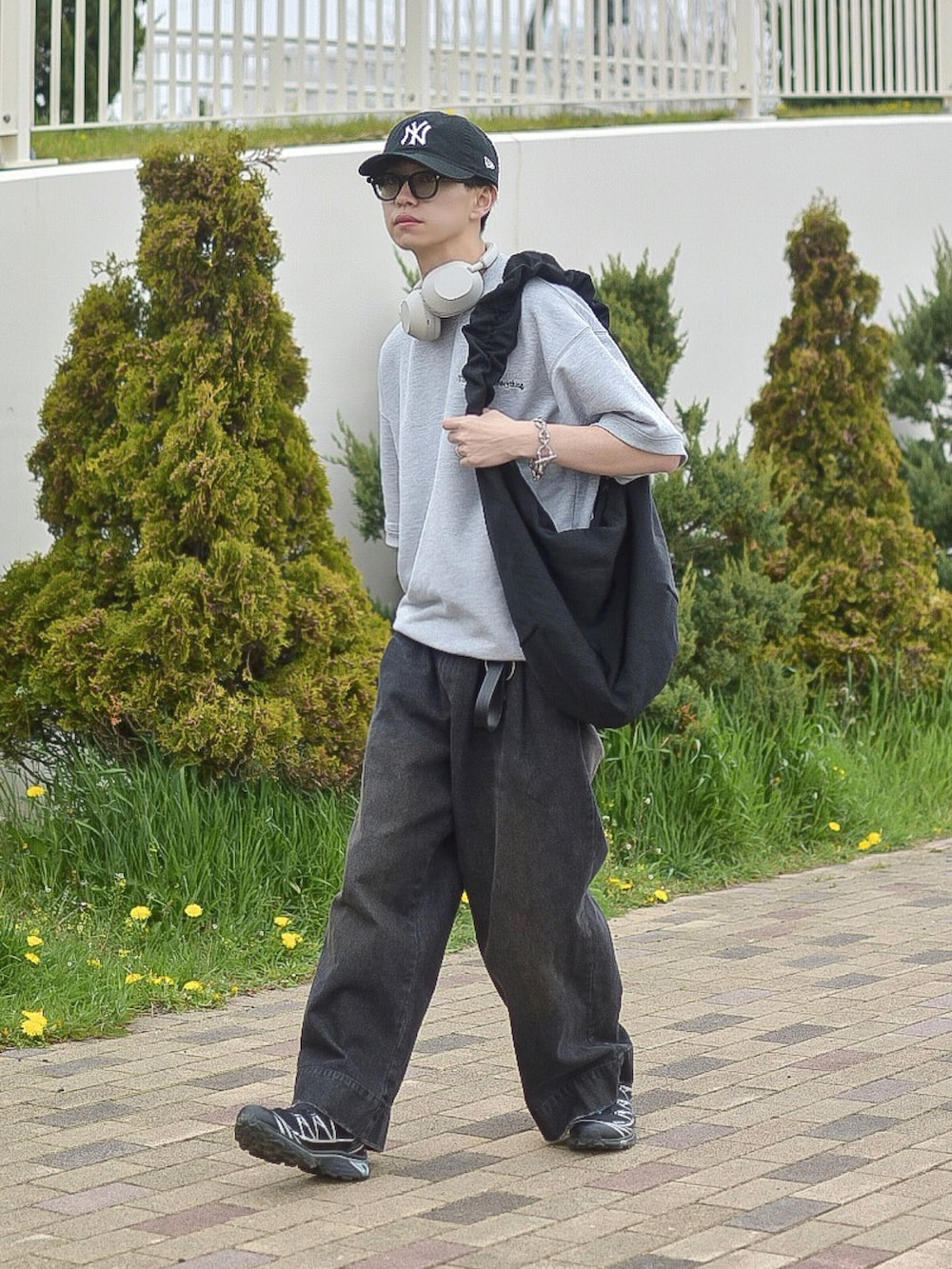 ブラック系のデニムパンツ、グレー系のTシャツ/カットソー、ブラック系のショルダーバッグを着用したメンズの春コーディネートの4枚目の写真