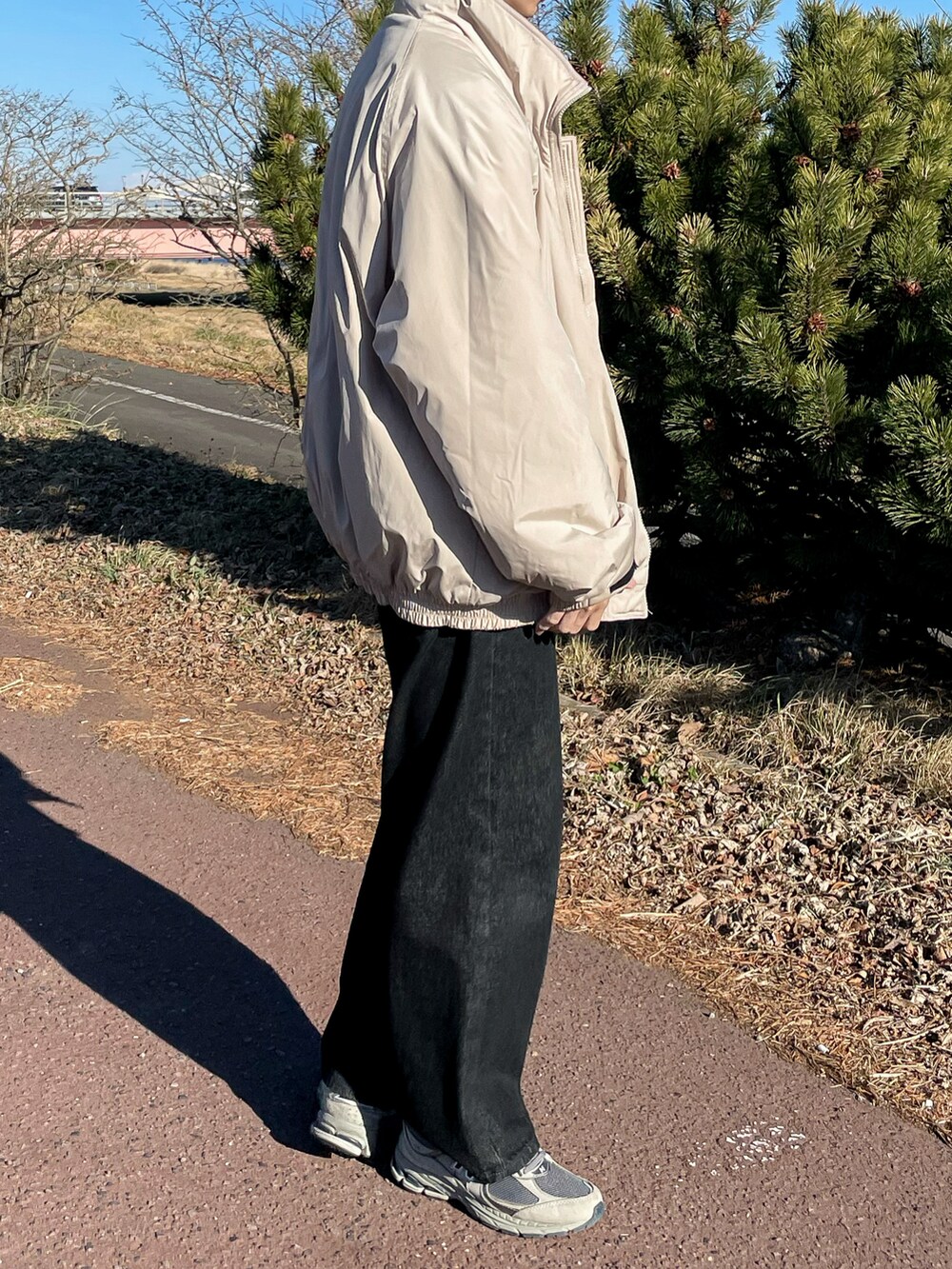 ベージュ系のジャケット/アウター、ブラック系のデニムパンツ、グレー系のスニーカーを着用したメンズの冬コーディネートの4枚目の写真