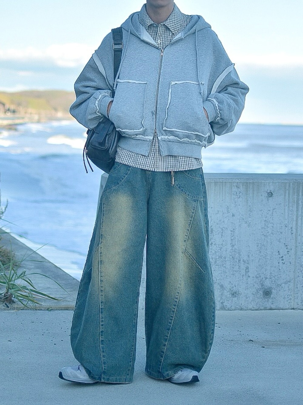 グレー系のパーカー、ホワイト系のシャツ/ブラウス、ブルー系のデニムパンツを着用したメンズの秋コーディネートの3枚目の写真