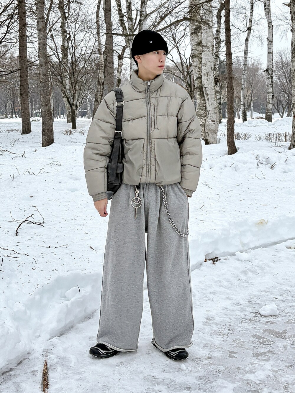 グレー系のスウェットパンツ、ブラック系のショルダーバッグ、グレー系のダウンジャケット/コートを着用したメンズの冬コーディネートの2枚目の写真