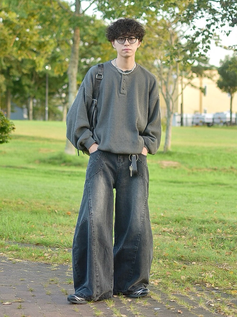 ブラック系のデニムパンツ、グレー系のTシャツ/カットソー、ブラック系のショルダーバッグを着用したメンズの秋コーディネートの2枚目の写真