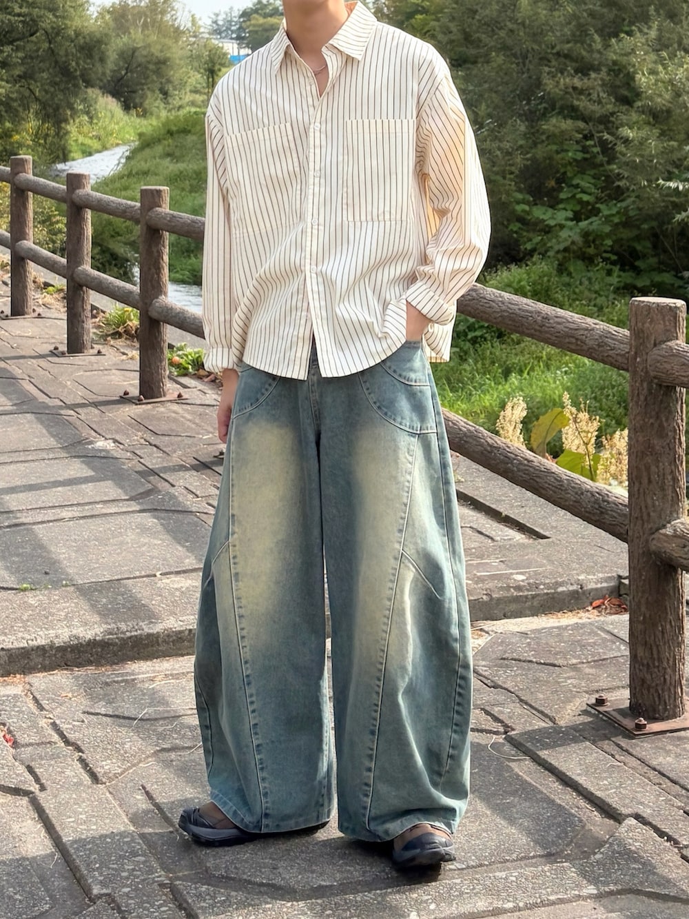 ブルー系のデニムパンツ、ブラウン系のスニーカー、イエロー系のシャツ/ブラウスを着用したメンズの秋コーディネートの3枚目の写真