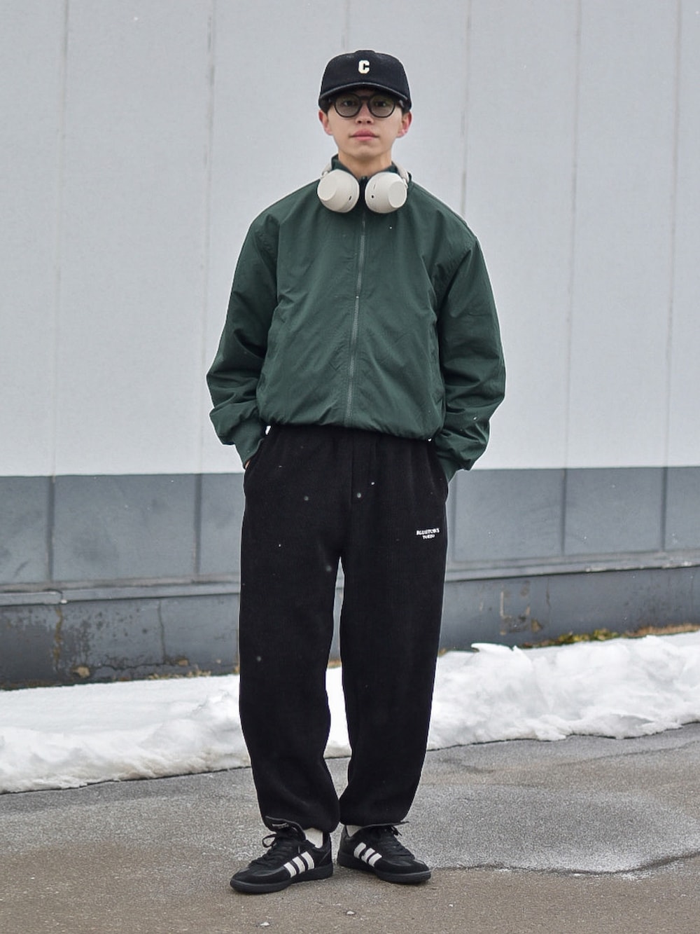 グレー系のジャケット/アウター、ブラック系のパンツ、ブラック系のキャップを着用したメンズの冬コーディネートの2枚目の写真