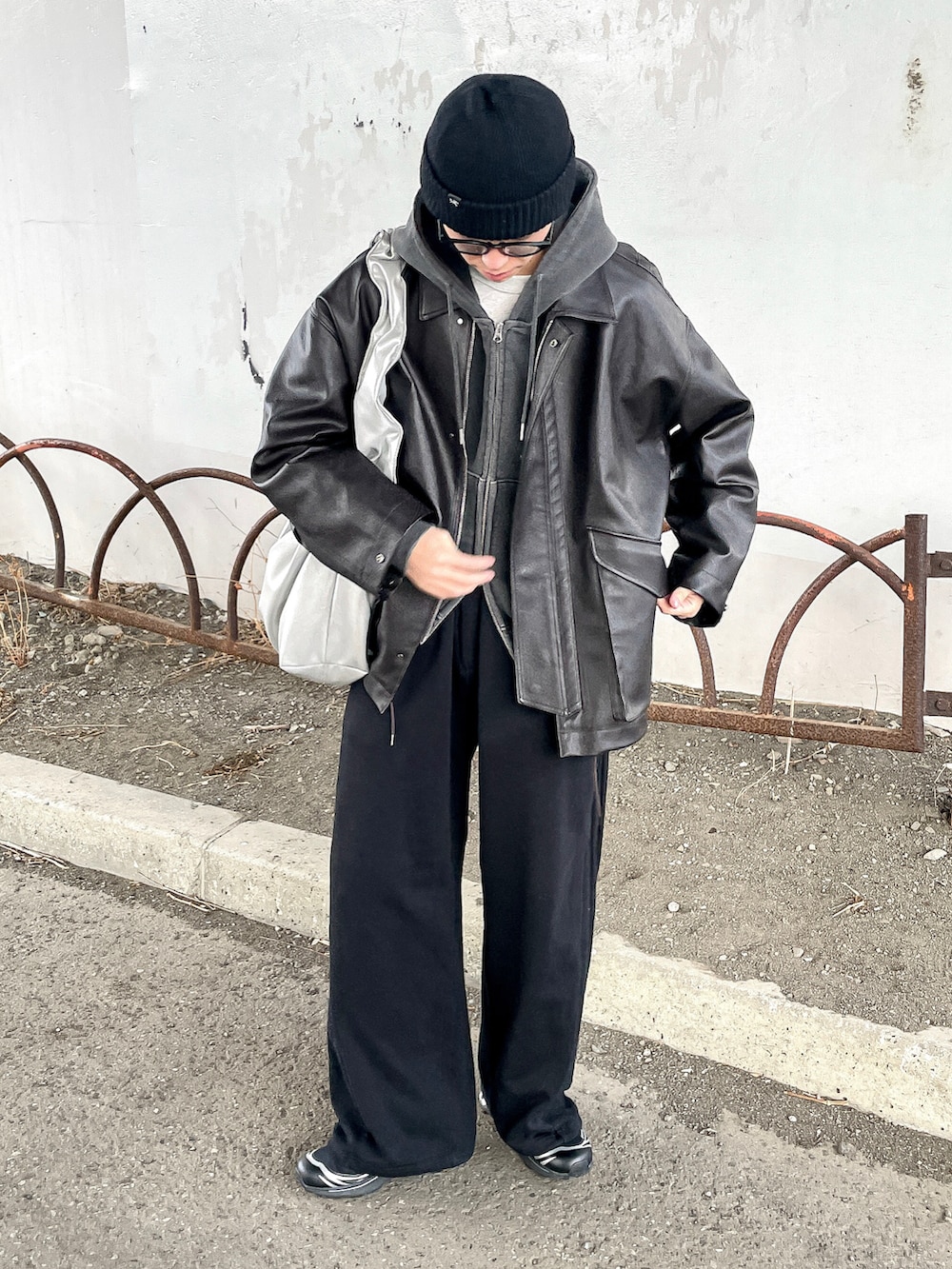 グレー系のパーカー、ブラウン系のブルゾン、ブラック系のスウェットパンツを着用したメンズの冬コーディネートの2枚目の写真