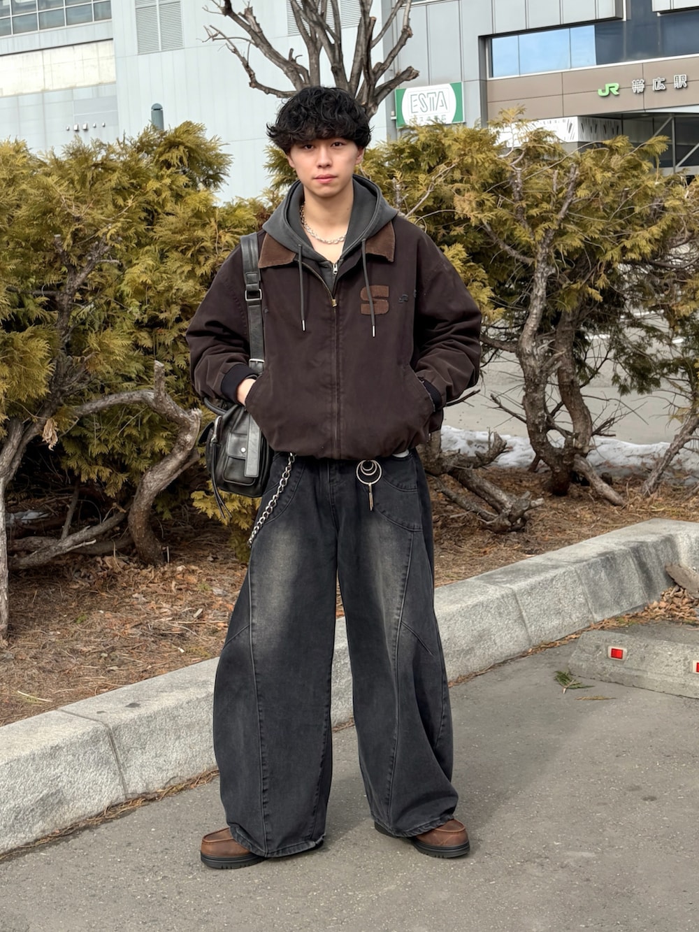 ブラック系のブルゾン、ブラック系のデニムパンツ、ブラウン系のブーツを着用したメンズの春コーディネートの3枚目の写真