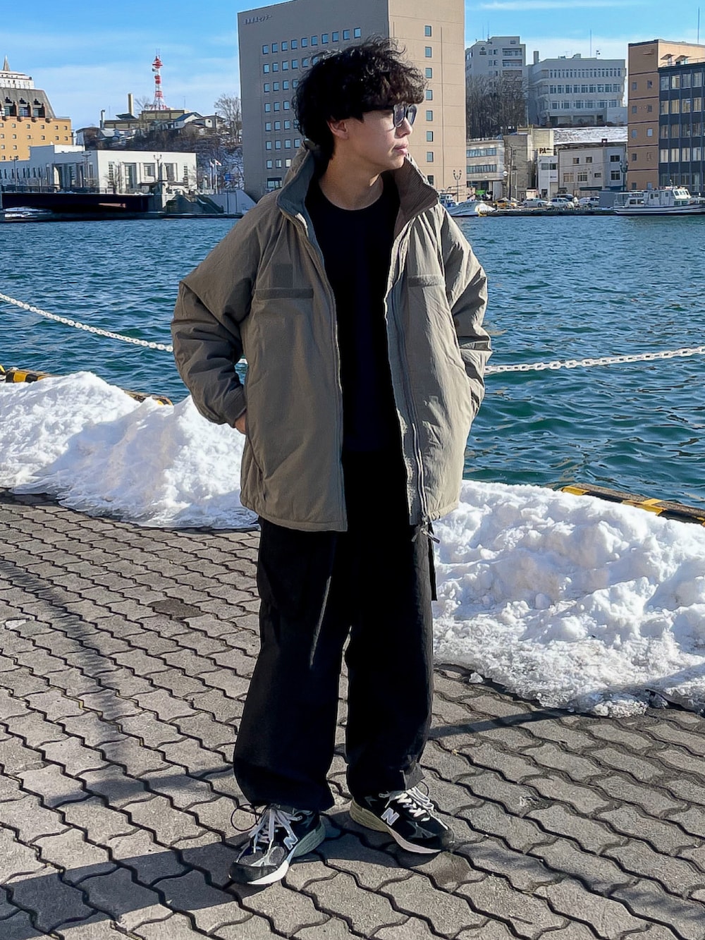 グリーン系のブルゾン、ブルー系のスウェット、ブラック系のカーゴパンツを着用したメンズの冬コーディネートの2枚目の写真