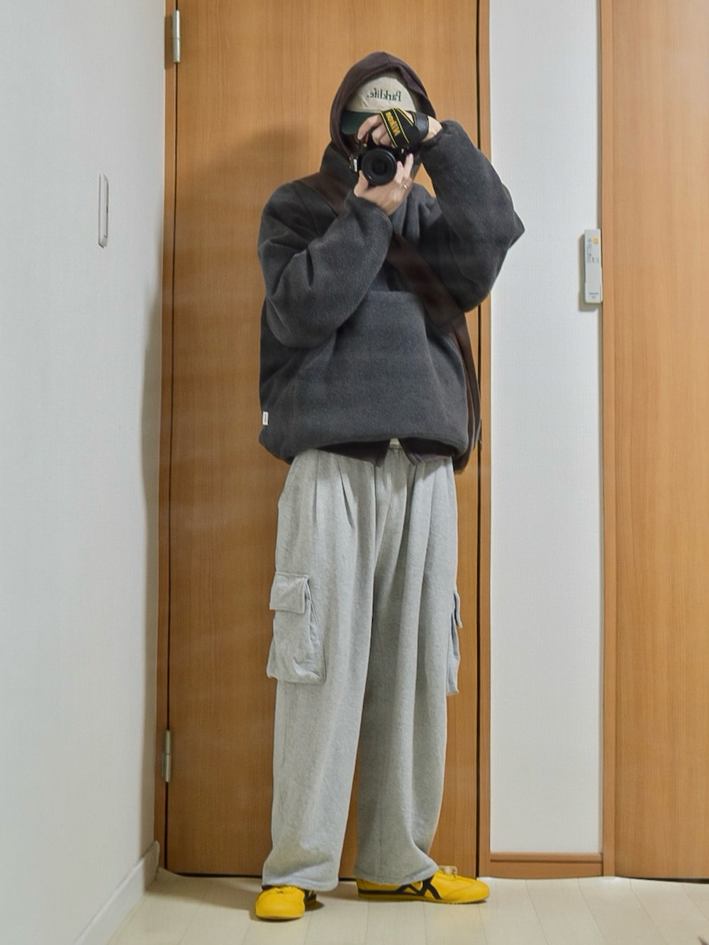 ブラック系のブルゾン、ブラウン系のパーカー、グレー系のスウェットパンツを着用したメンズの冬コーディネートの3枚目の写真