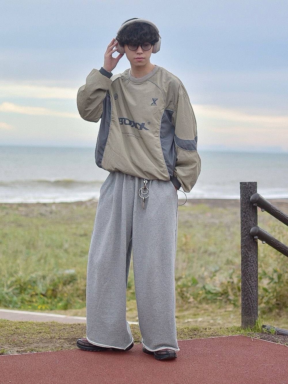 グリーン系のスウェット、グレー系のスウェットパンツ、ブラウン系のスニーカーを着用したメンズの秋コーディネートの2枚目の写真