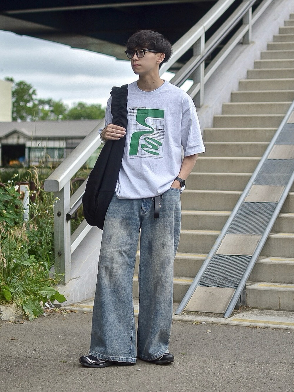 グレー系のTシャツ/カットソー、ブルー系のデニムパンツ、ブラック系のショルダーバッグを着用したメンズの夏コーディネートの2枚目の写真