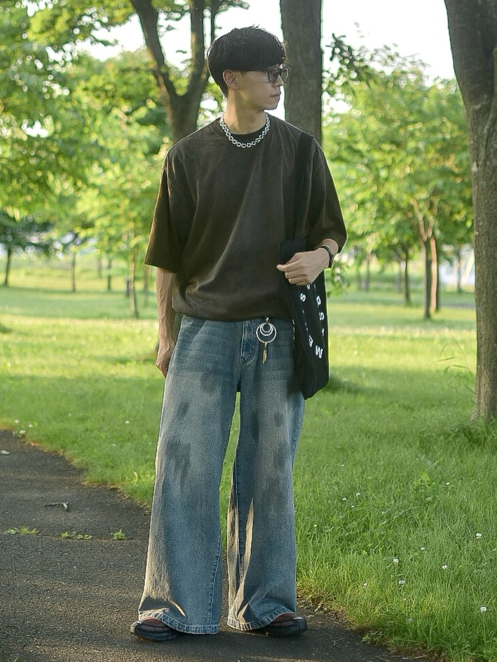 ブラウン系のTシャツ/カットソー、ブルー系のデニムパンツ、ブラウン系のスニーカーを着用したメンズの夏コーディネートの2枚目の写真