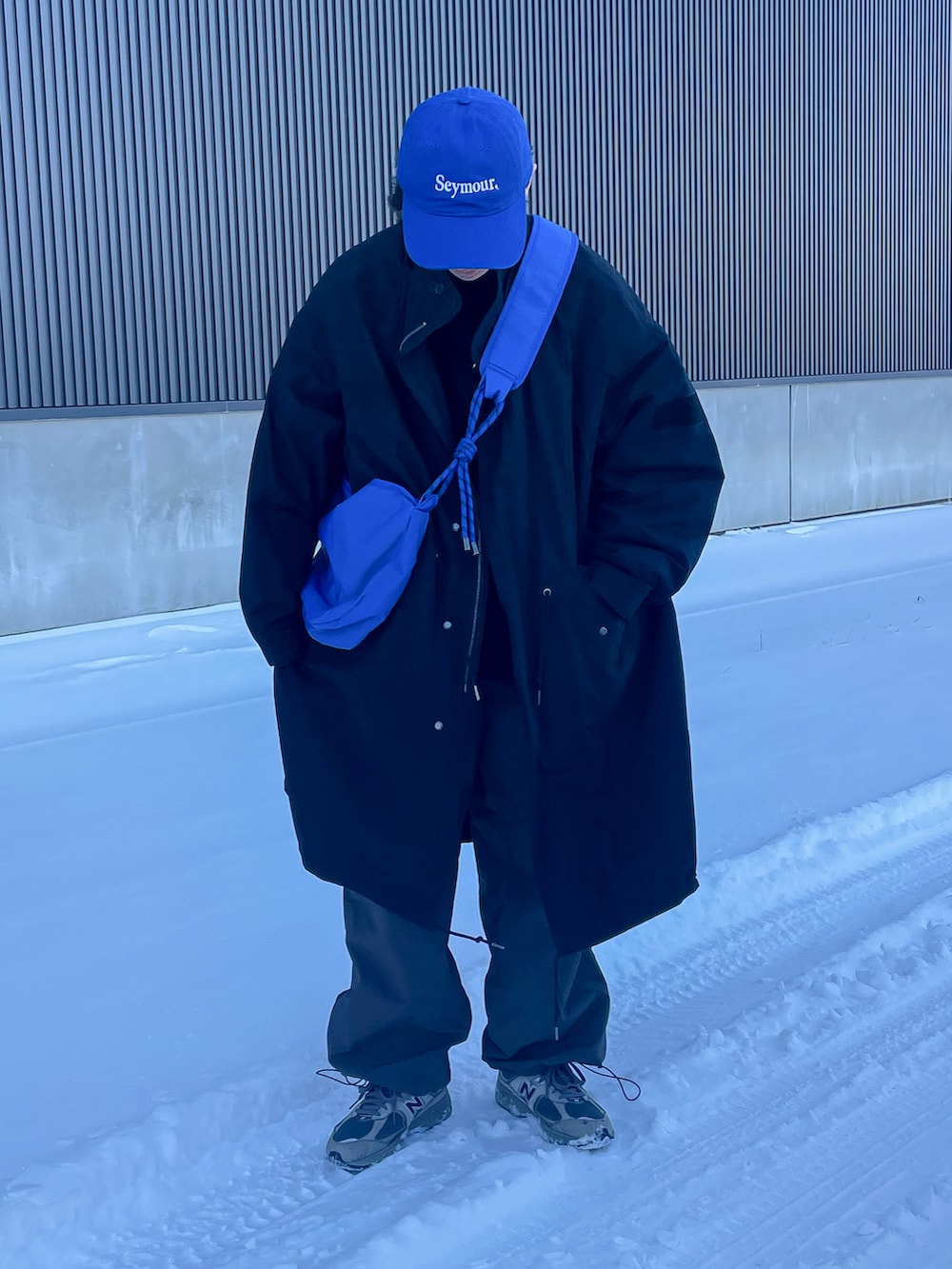 グレー系のカーゴパンツ、ブラック系のスウェット、ブラック系のモッズコートを着用したメンズの冬コーディネートの2枚目の写真