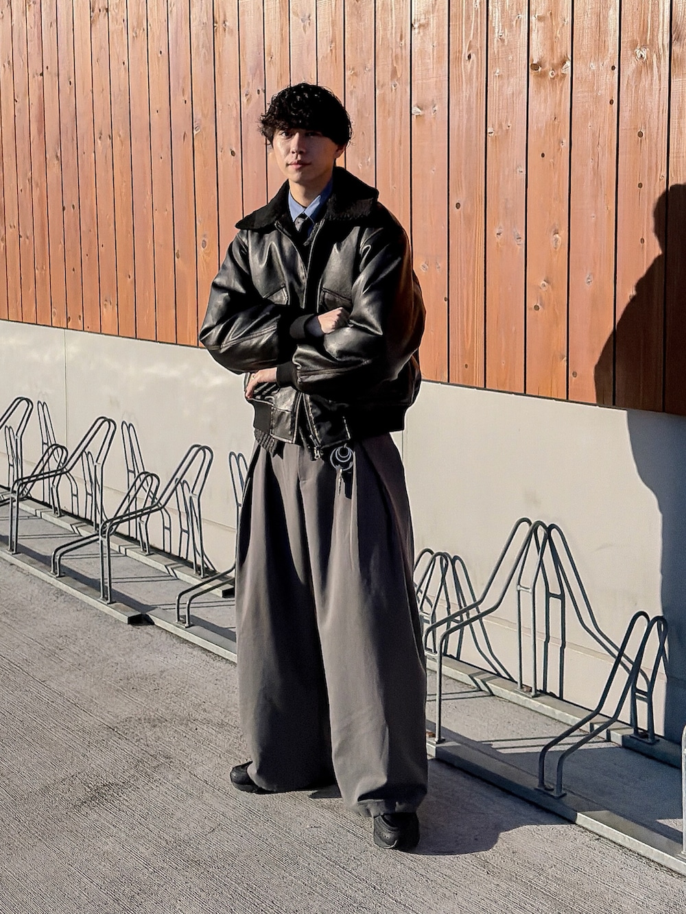 ブラック系のニット/セーター、ブルー系のシャツ/ブラウス、ブラック系のブルゾンを着用したメンズの冬コーディネートの4枚目の写真