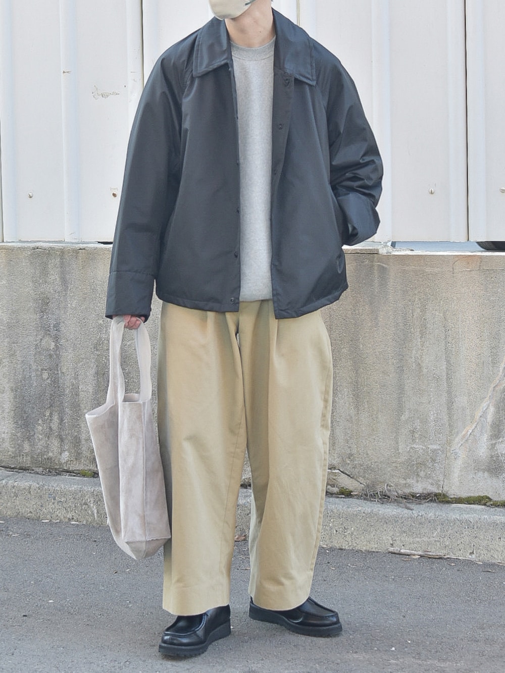 ブラック系のその他アウター、ベージュ系のトートバッグを着用したメンズの春コーディネートの3枚目の写真
