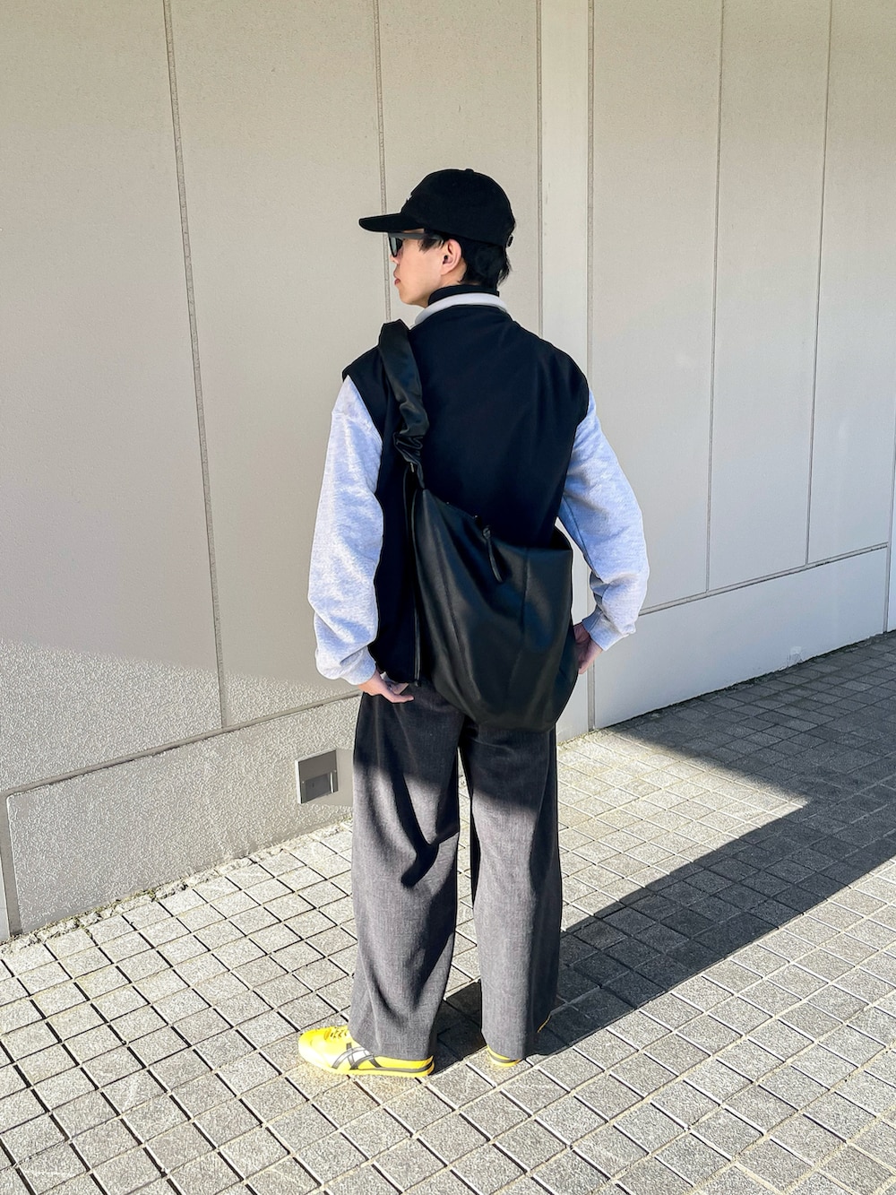 ブラック系のブルゾン、グレー系のスウェット、グレー系のスラックスを着用したメンズの秋コーディネートの5枚目の写真