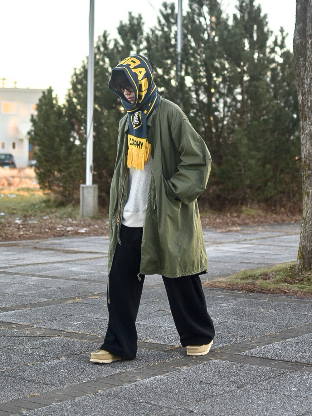 ブラック系のスウェットパンツ、グレー系のスウェット、ベージュ系のモカシン/デッキシューズを着用したメンズの冬コーディネートの2枚目の写真