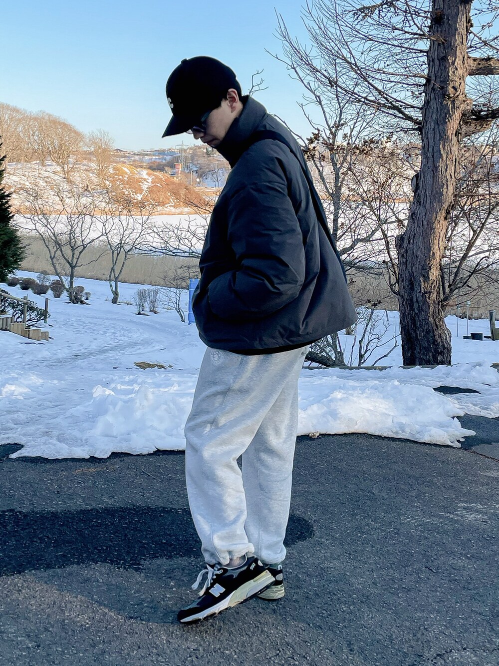 グレー系のジャケット/アウター、ホワイト系のスウェットパンツ、ブラック系のシューズを着用したメンズの冬コーディネートの2枚目の写真