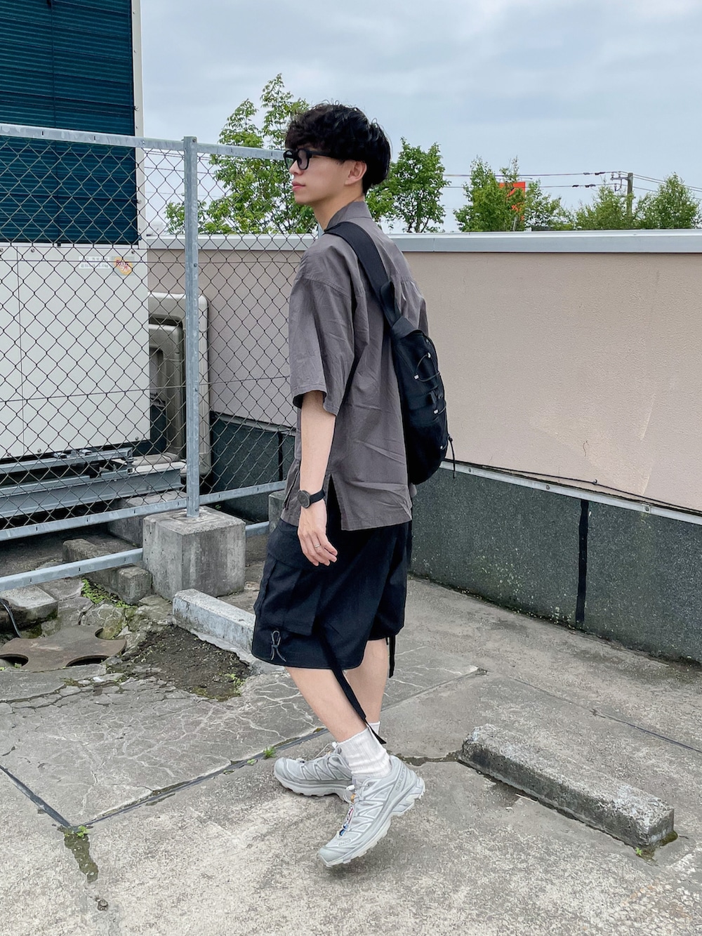 ブラック系のカーゴパンツ、グレー系のシャツ/ブラウス、ブラック系のショルダーバッグを着用したメンズの夏コーディネートの3枚目の写真