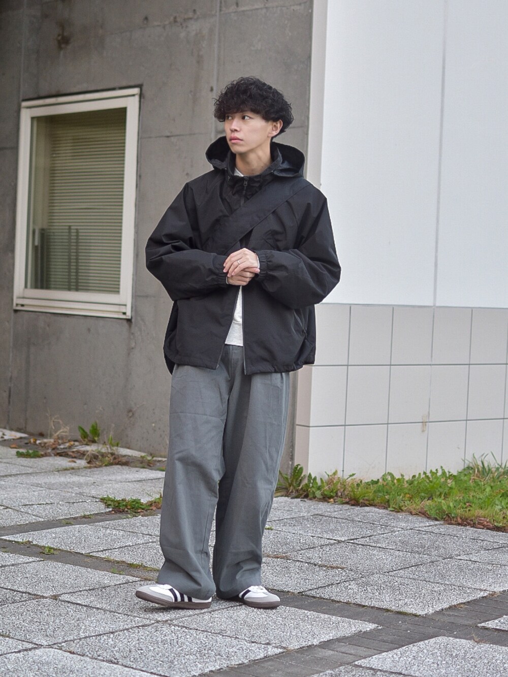 グレー系のデニムパンツ、ブラック系のブルゾン、ベージュ系のスウェットを着用したメンズの秋コーディネートの4枚目の写真