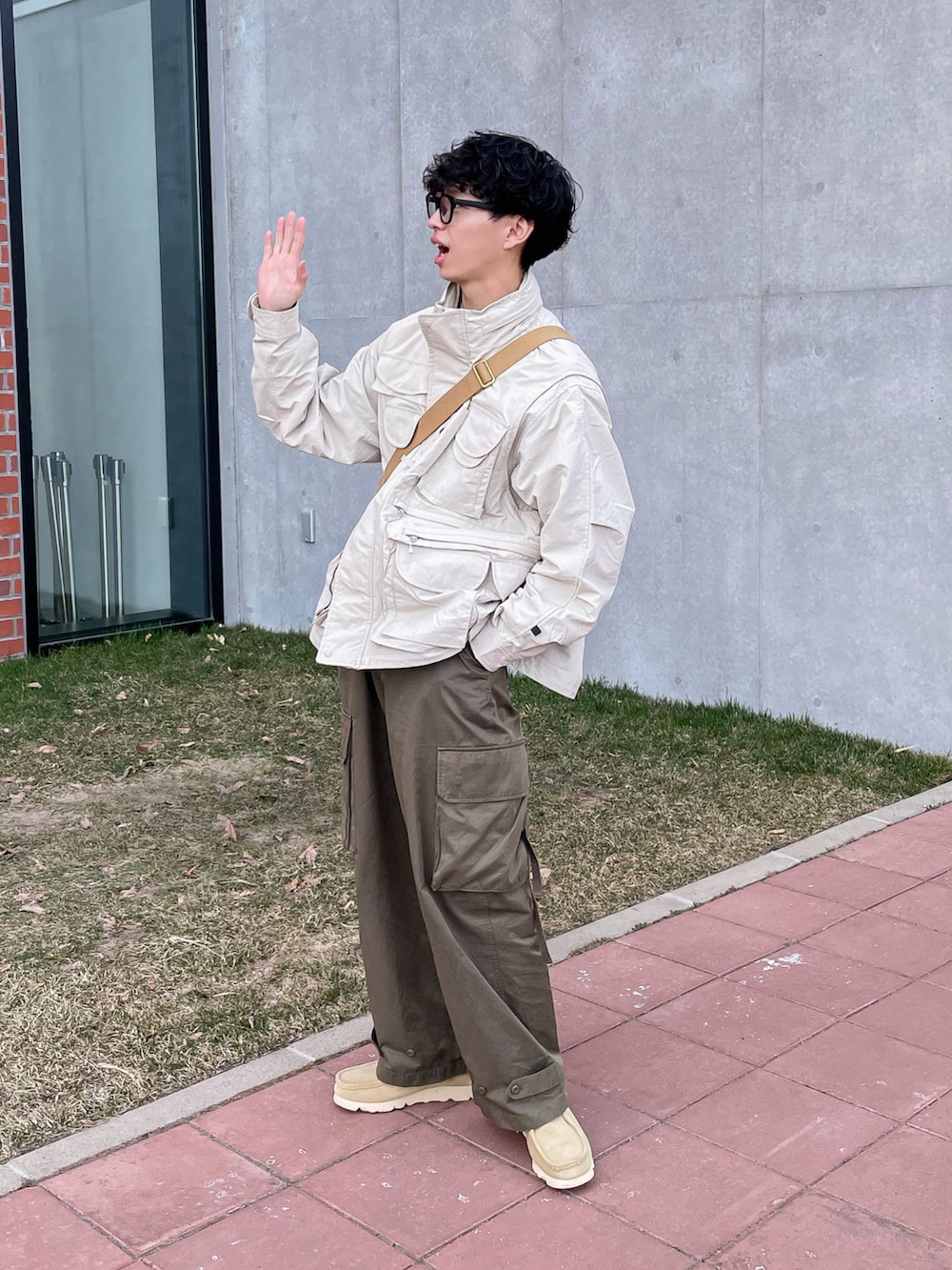 ベージュ系のブルゾン、ベージュ系のモカシン/デッキシューズ、グリーン系のカーゴパンツを着用したメンズの春コーディネートの4枚目の写真