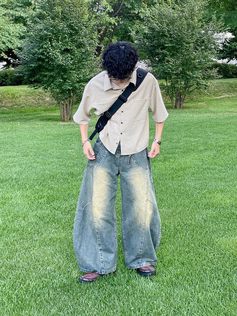 ブラウン系のスニーカー、ベージュ系のシャツ/ブラウス、ブルー系のデニムパンツを着用したメンズの夏コーディネートの4枚目の写真