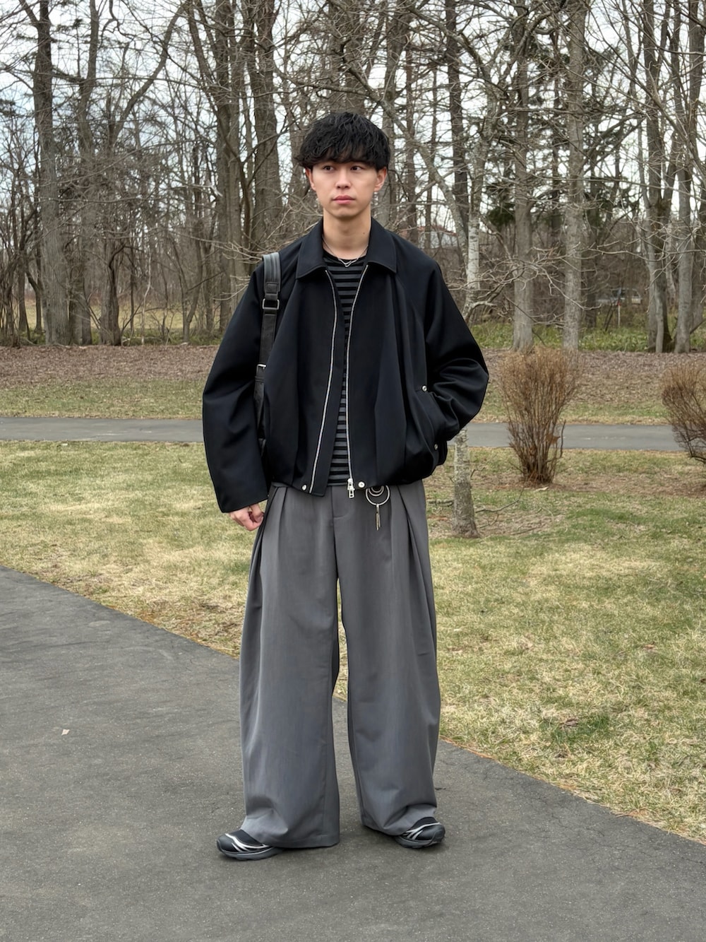 ブラック系のTシャツ/カットソー、その他のブルゾン、グレー系のスラックスを着用したメンズの春コーディネートの3枚目の写真
