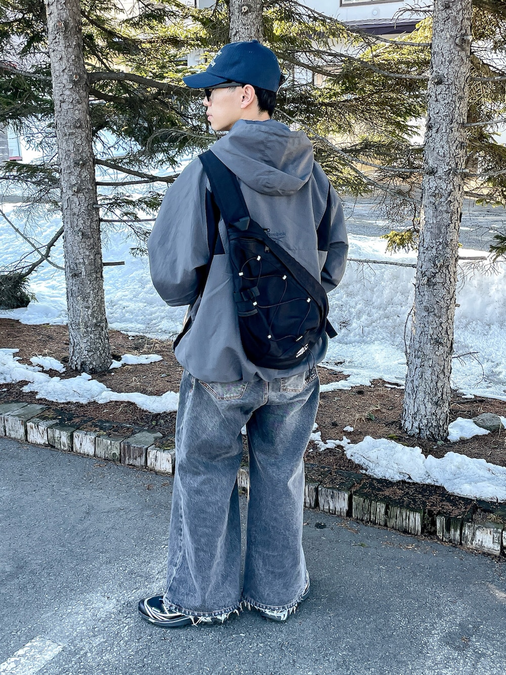 グレー系のナイロンジャケット、ブルー系のシャツ/ブラウス、ブラック系のデニムパンツを着用したメンズの春コーディネートの4枚目の写真