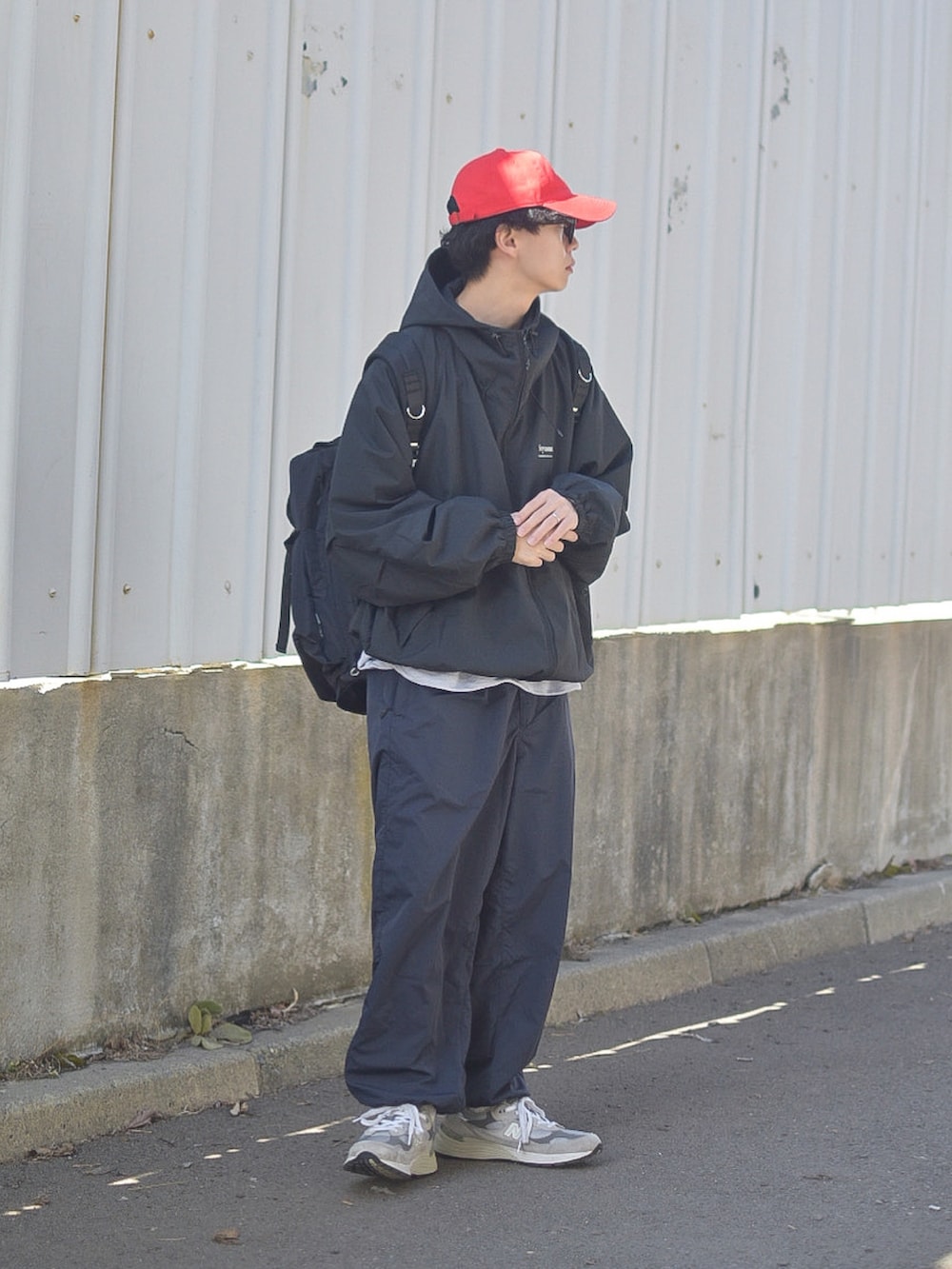 ブラック系のその他パンツ、ブラック系のバックパック/リュック、グレー系のスニーカーを着用したメンズの春コーディネートの3枚目の写真