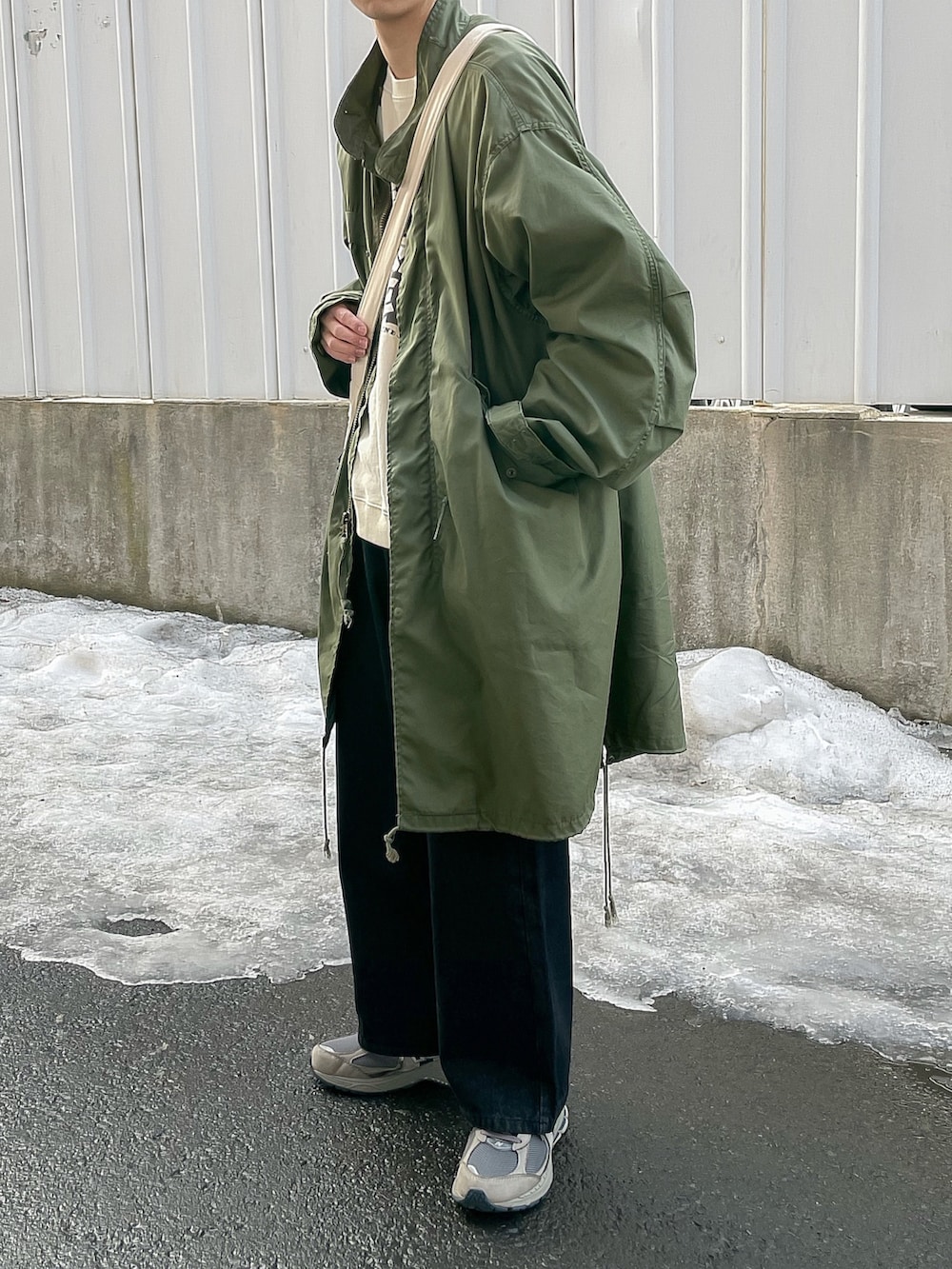 ホワイト系のスウェット、ブラック系のデニムパンツを着用したメンズの春コーディネートの3枚目の写真