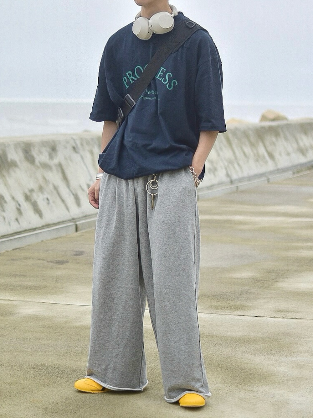 ブルー系のTシャツ/カットソー、グレー系のスウェットパンツ、イエロー系のスニーカーを着用したメンズの夏コーディネートの2枚目の写真