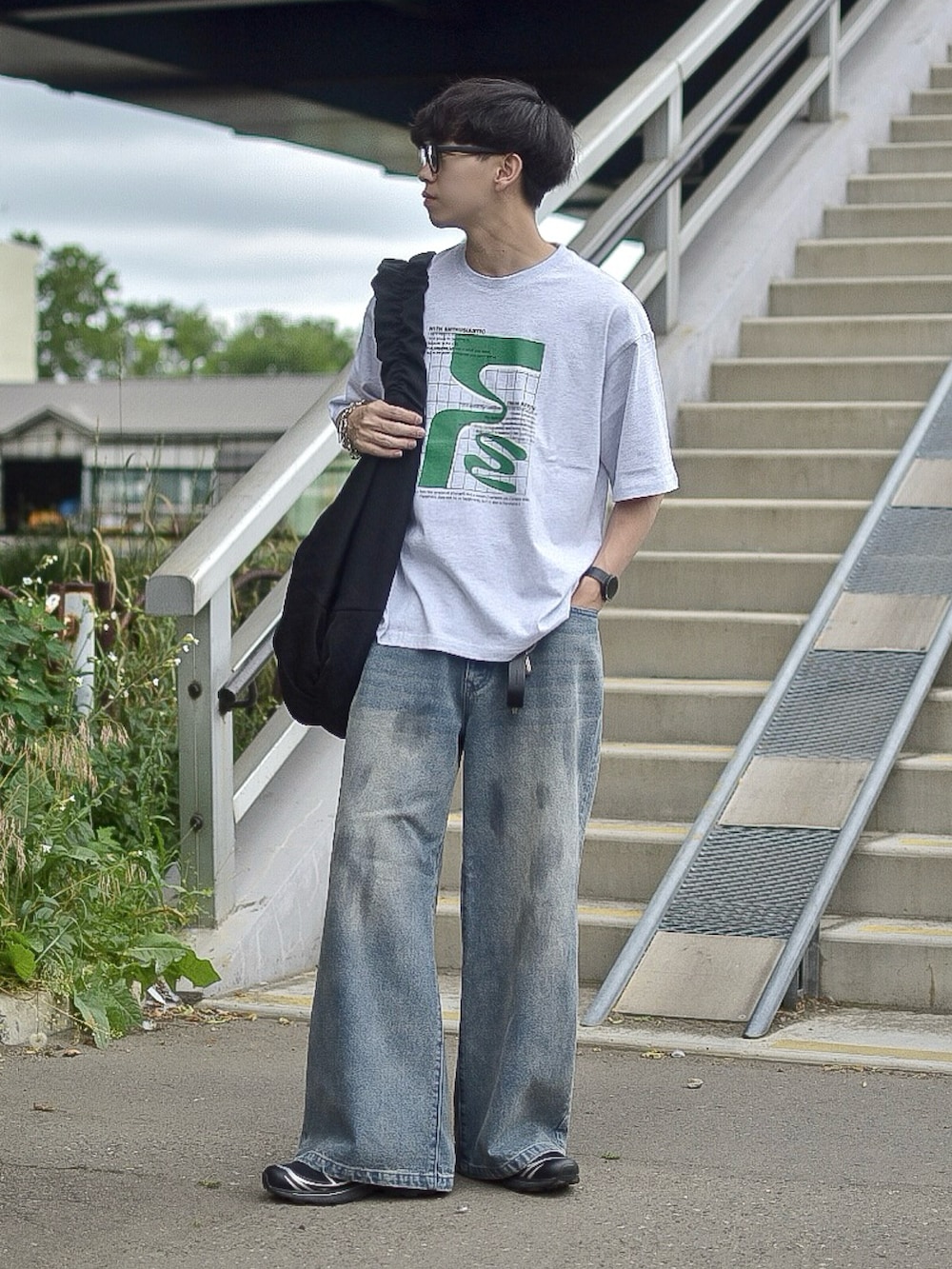 グレー系のTシャツ/カットソー、ブルー系のデニムパンツ、ブラック系のショルダーバッグを着用したメンズの夏コーディネートの4枚目の写真