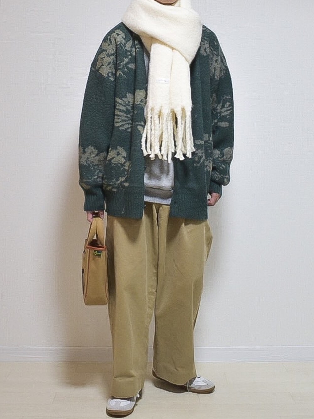 グリーン系のカーディガン/ボレロ、ホワイト系のマフラーを着用したメンズの冬コーディネートの2枚目の写真