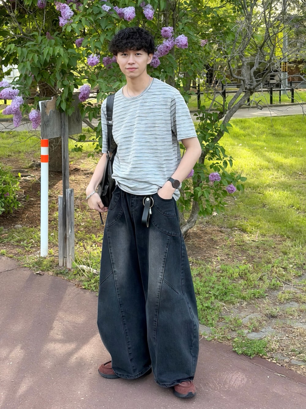 グレー系のTシャツ/カットソー、ブラック系のデニムパンツ、ブラウン系のスニーカーを着用したメンズの夏コーディネートの2枚目の写真