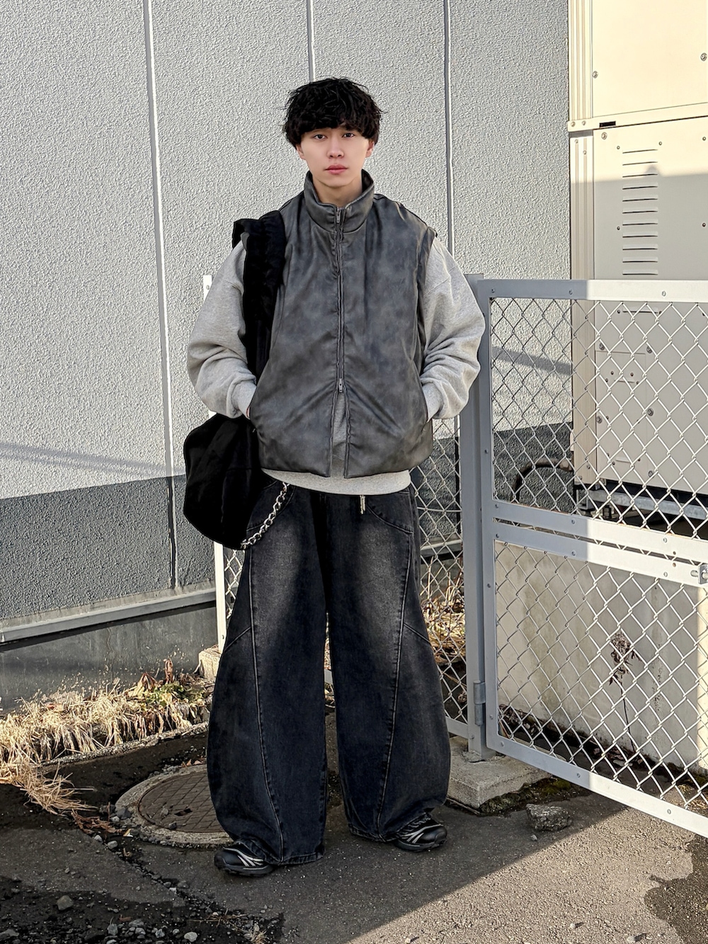 ブラック系のダウンジャケット/コート、グレー系のスウェット、ブラック系のデニムパンツを着用したメンズの冬コーディネートの2枚目の写真