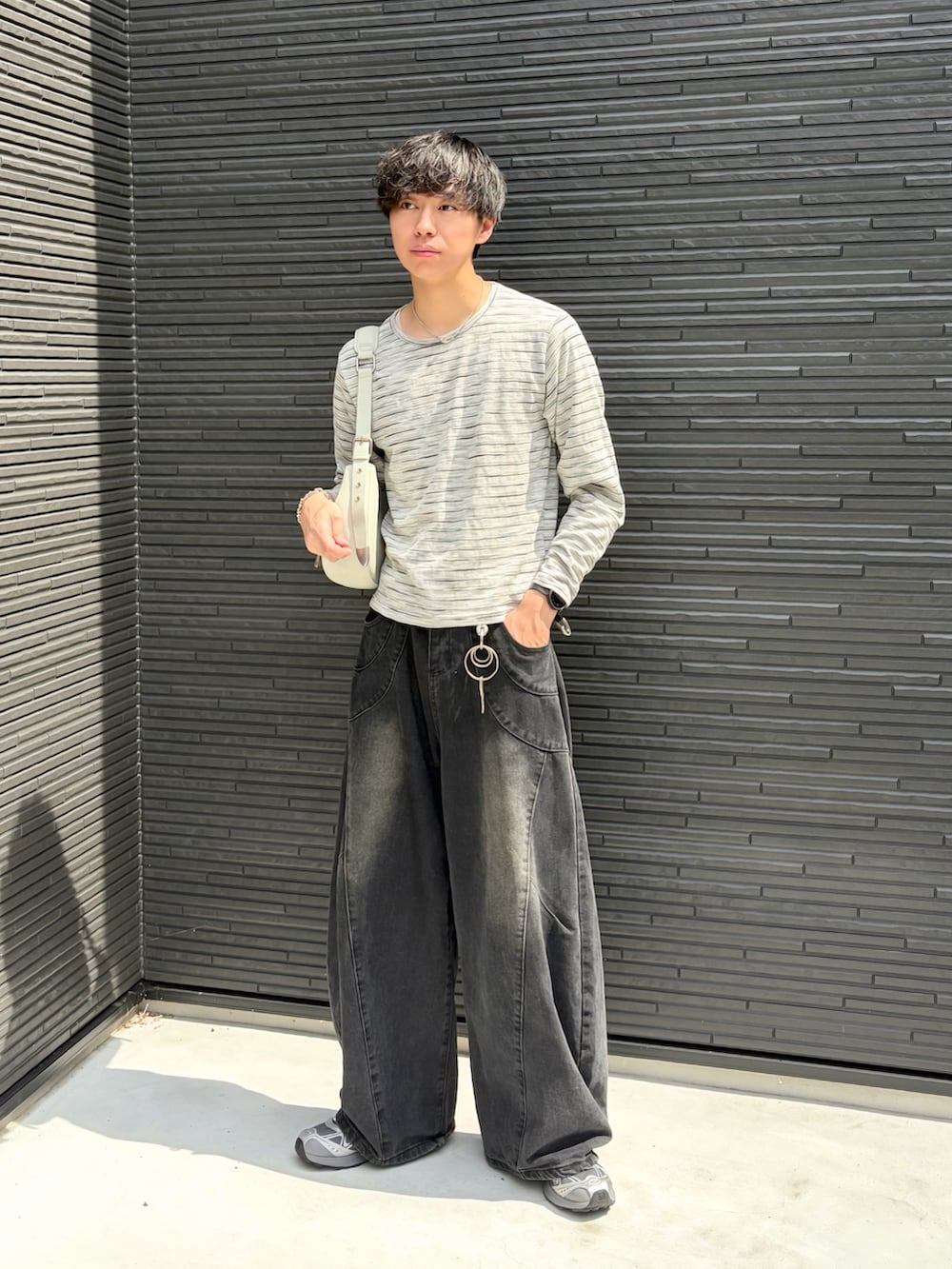 グレー系のTシャツ/カットソー、ブラック系のデニムパンツ、グリーン系のショルダーバッグを着用したメンズの秋コーディネートの2枚目の写真